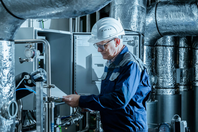 Engineers performing validation and maintenance on pharmaceutical process systems